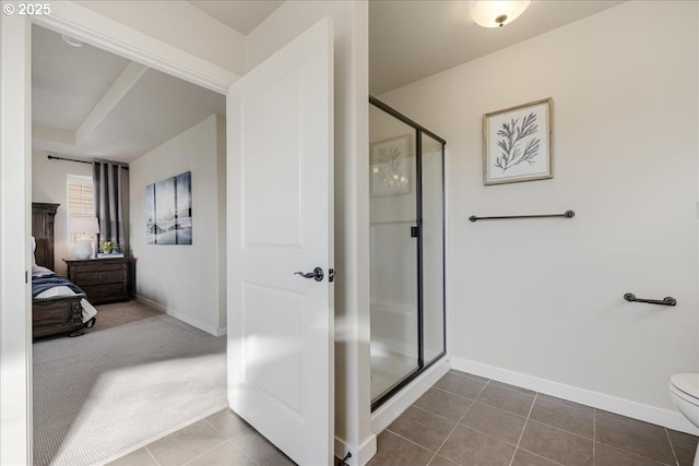 bathroom with tile patterned flooring, a shower with door, and toilet