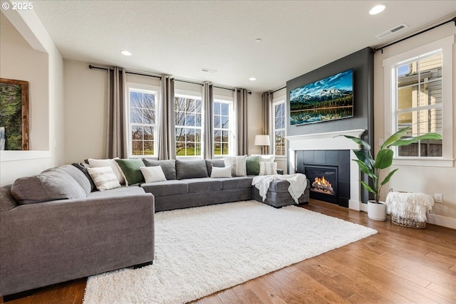 living room featuring hardwood / wood-style flooring and a tile fireplace