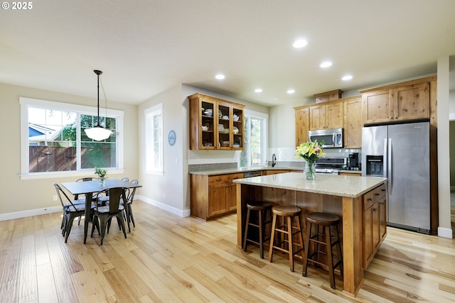 11862 White Ln, Oregon City, OR 97045 - kitchen with appliances with stainless steel finishes, light wood-type flooring, a kitchen bar, a kitchen island, and recessed lighting
