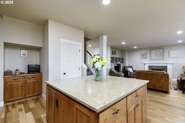 11862 White Ln, Oregon City, OR 97045 - kitchen with a tile fireplace, light wood-style floors, recessed lighting, light stone counters, and a kitchen island