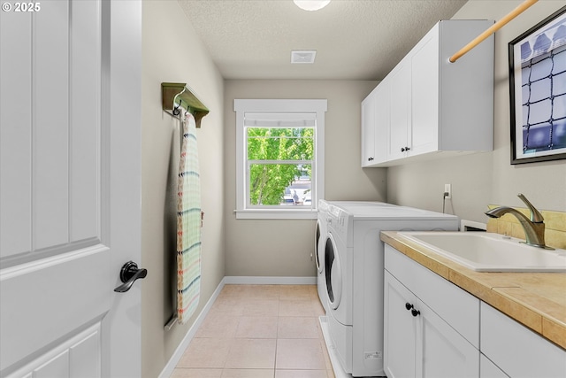 18289 SW Maidenfern Ln, Sherwood, OR 97140 - laundry room featuring cabinet space, washing machine and dryer, a textured ceiling, light tile patterned floors, and baseboards