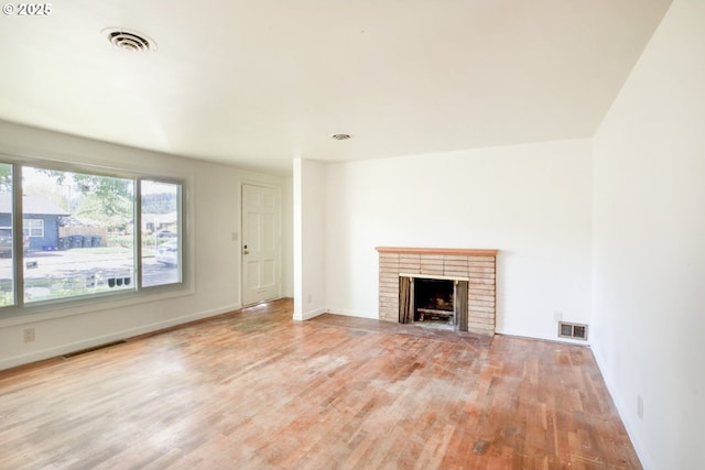 unfurnished living room with wood finished floors, a fireplace, and baseboards