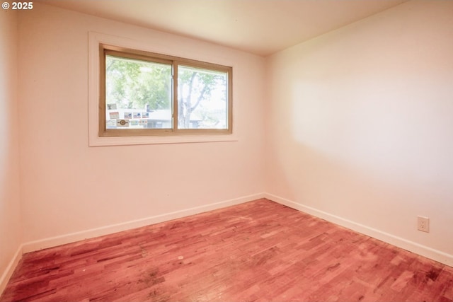 unfurnished room featuring baseboards and light wood-style floors