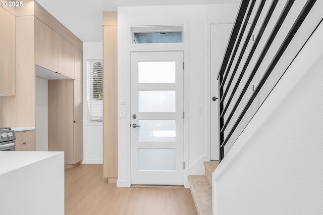 foyer with light wood-type flooring and stairway