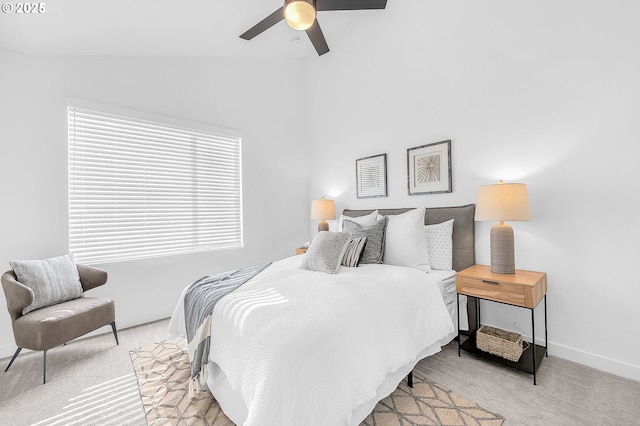 bedroom with light carpet, a ceiling fan, baseboards, and vaulted ceiling