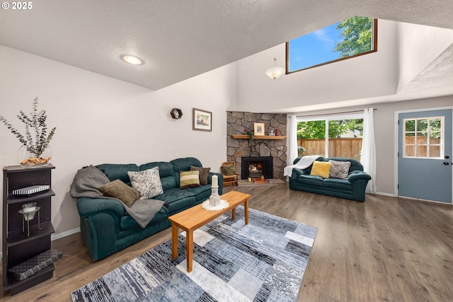 14805 SW 109th Ave, Portland, OR 97224 - living area with a textured ceiling, wood finished floors, a stone fireplace, and baseboards