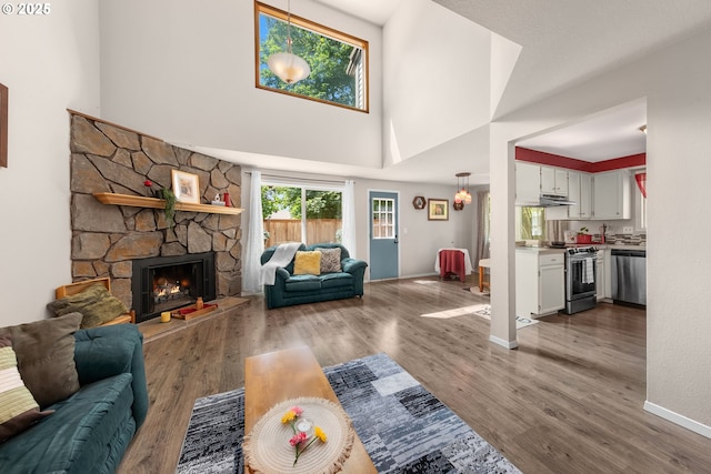14805 SW 109th Ave, Portland, OR 97224 - living area featuring a towering ceiling, wood finished floors, baseboards, and a fireplace