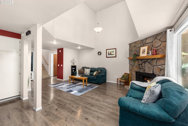 14805 SW 109th Ave, Portland, OR 97224 - living room with baseboards, wood finished floors, stairway, a stone fireplace, and high vaulted ceiling