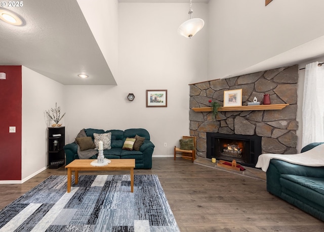 14805 SW 109th Ave, Portland, OR 97224 - living area with wood finished floors, baseboards, a high ceiling, and a stone fireplace