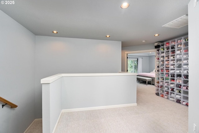 corridor with recessed lighting, visible vents, an upstairs landing, and carpet flooring