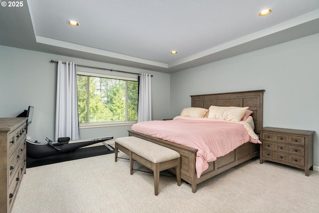 bedroom with a raised ceiling, recessed lighting, and light colored carpet