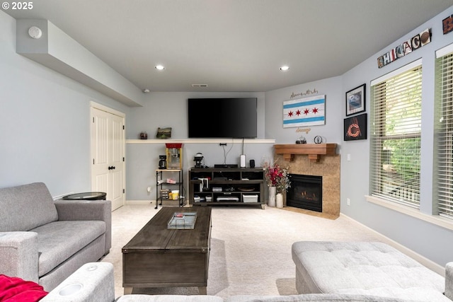 carpeted living area with a tiled fireplace, visible vents, recessed lighting, and baseboards