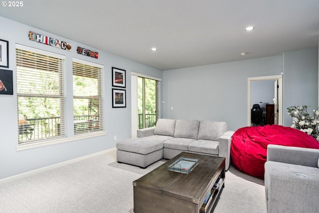 carpeted living area featuring recessed lighting and baseboards