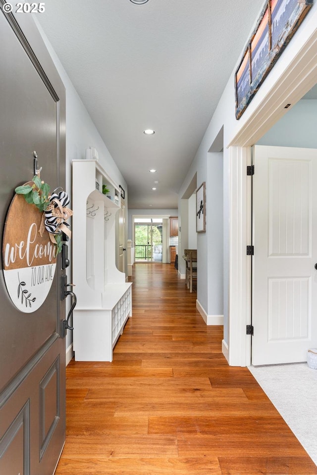 corridor with recessed lighting, light wood-type flooring, and baseboards