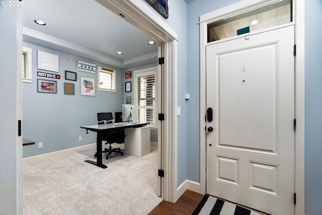 foyer entrance featuring recessed lighting, baseboards, and dark carpet