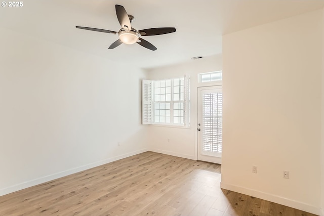 empty room with light wood-style floors, visible vents, ceiling fan, and baseboards