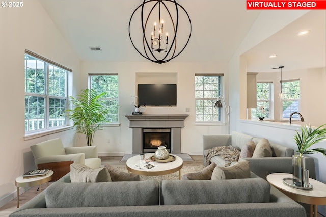 living room featuring lofted ceiling, a fireplace with raised hearth, visible vents, and recessed lighting