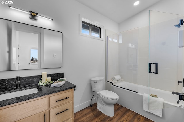 full bathroom with vanity, wood-type flooring, shower / bath combination with glass door, and toilet