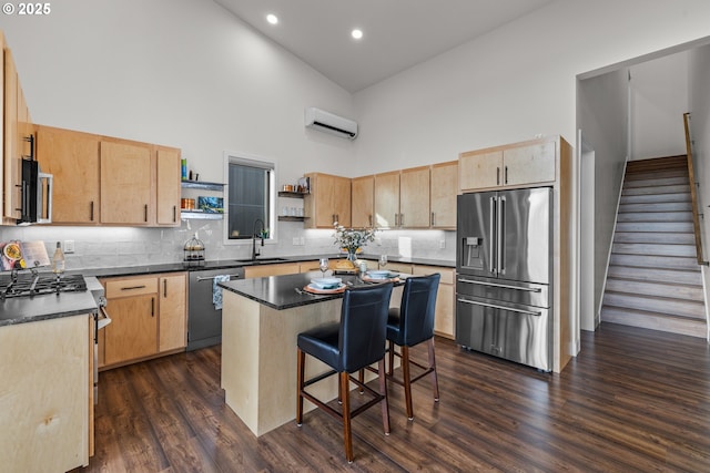 kitchen featuring sink, a wall mounted AC, high vaulted ceiling, a kitchen island, and stainless steel appliances