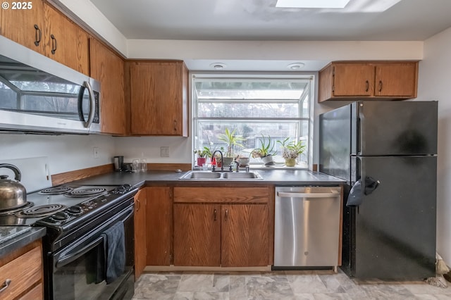 kitchen featuring a skylight, sink, and black appliances