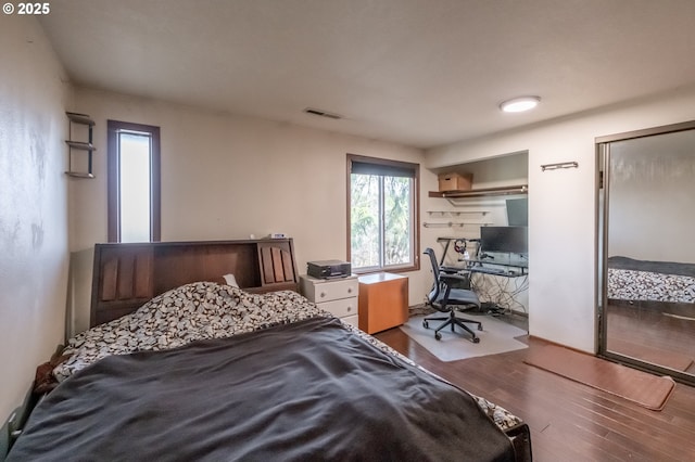 bedroom with two closets and hardwood / wood-style flooring