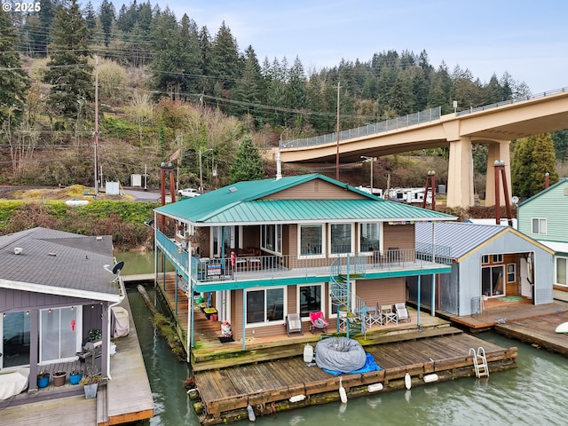 rear view of house featuring a deck with water view