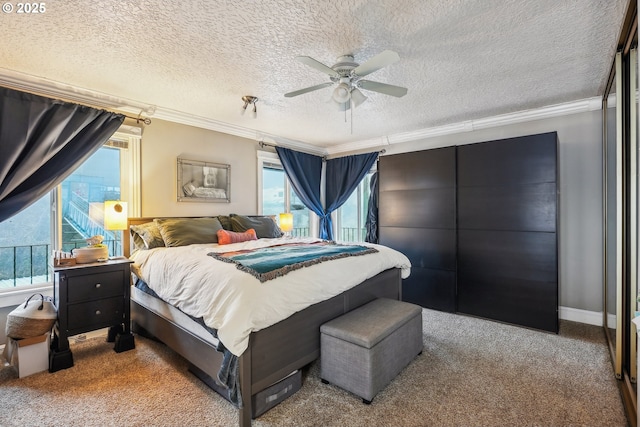 carpeted bedroom featuring ceiling fan, ornamental molding, and a textured ceiling