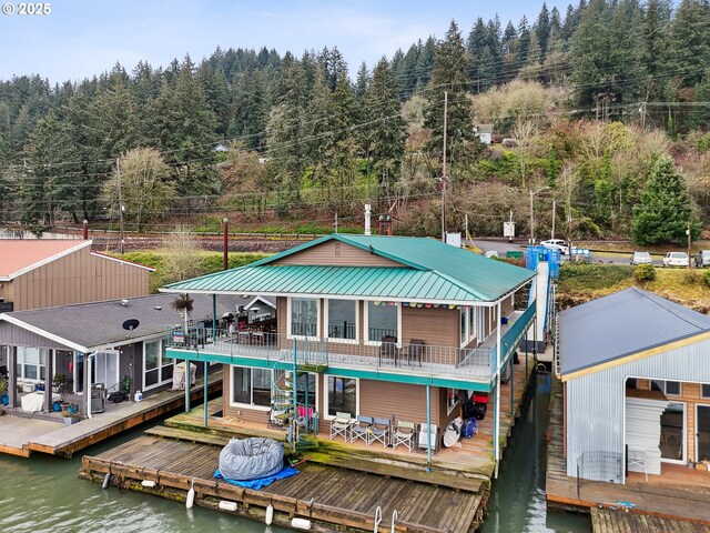 back of property with a deck with water view