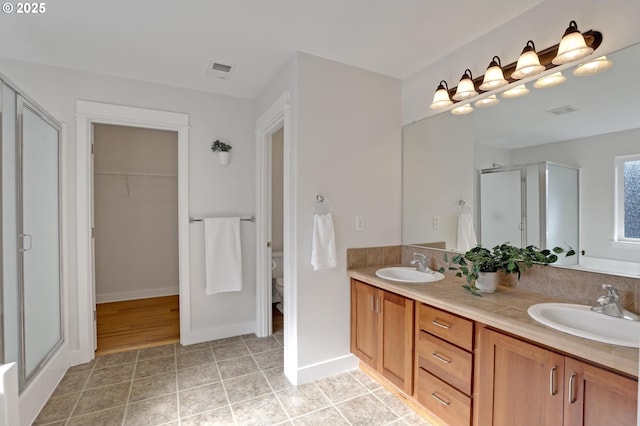 bathroom with walk in shower, tile patterned floors, vanity, and toilet