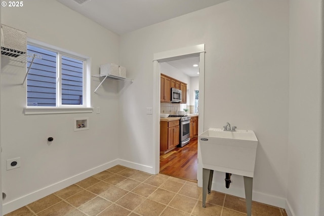 laundry room with light tile patterned flooring, hookup for an electric dryer, and hookup for a washing machine