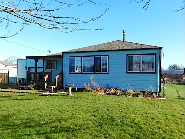 rear view of house featuring a lawn