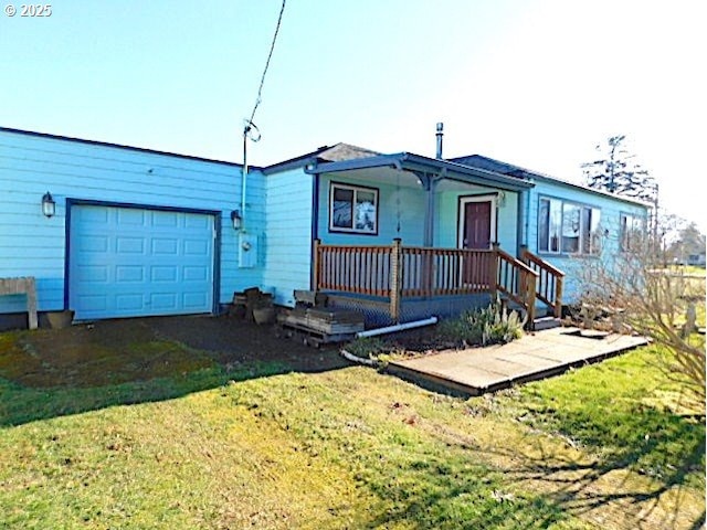 view of front of home with a front yard, a porch, and a garage