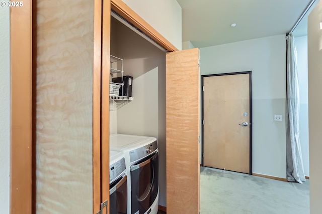 laundry room with laundry area, washer and dryer, and light colored carpet