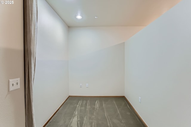 empty room with dark colored carpet and baseboards