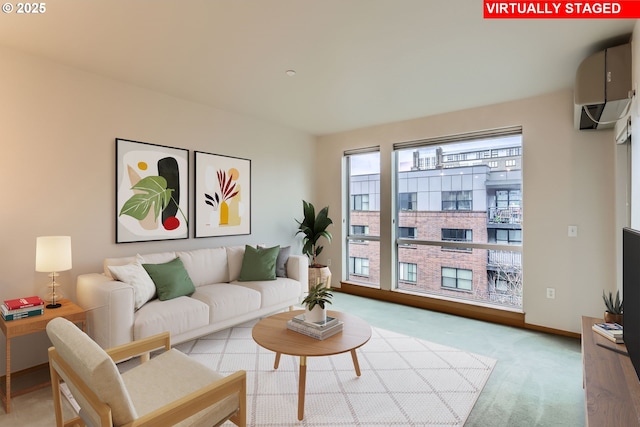 living area with light carpet, a wall unit AC, and baseboards