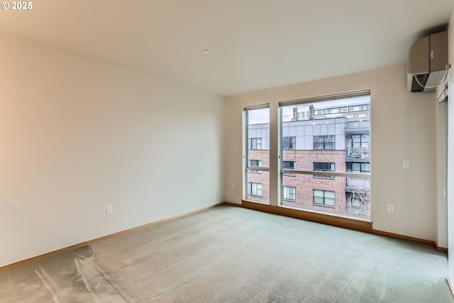 unfurnished room featuring carpet flooring, baseboards, and a wall mounted AC