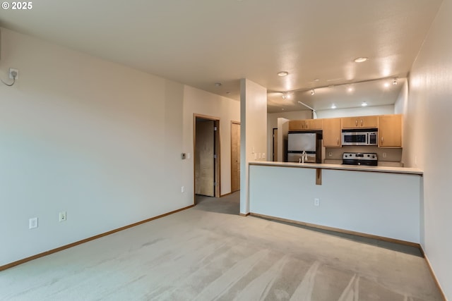 kitchen with light brown cabinets, light colored carpet, stainless steel appliances, baseboards, and light countertops