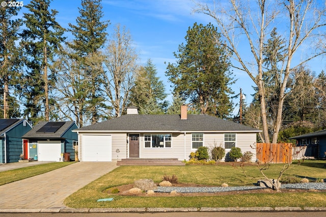 single story home featuring an outdoor structure, a front lawn, and solar panels