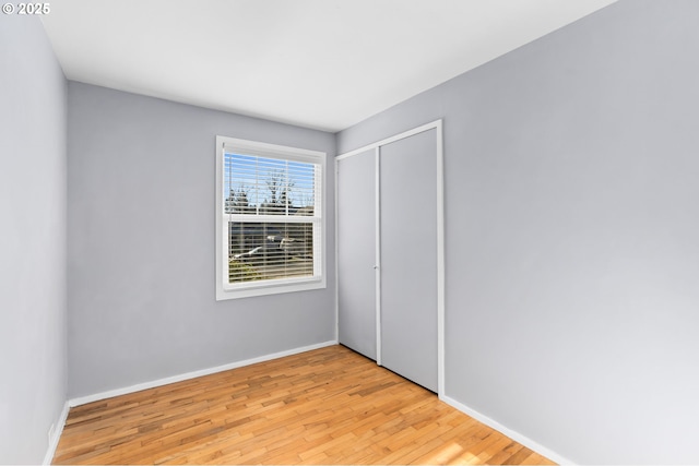 unfurnished bedroom with light hardwood / wood-style flooring and a closet