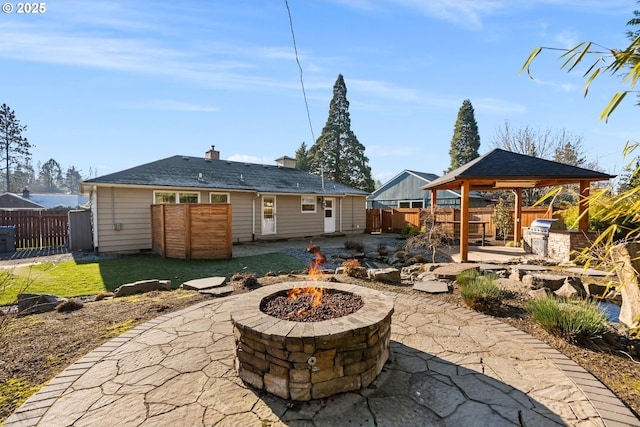 rear view of house featuring a gazebo, a patio, and an outdoor fire pit