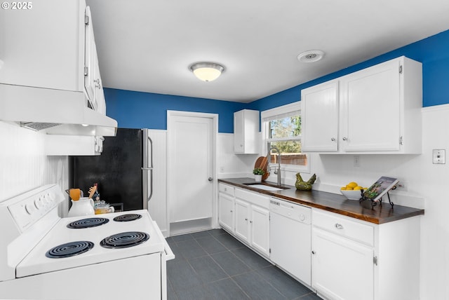 kitchen featuring sink, white appliances, dark tile patterned floors, extractor fan, and white cabinets