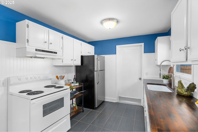 kitchen featuring sink, stainless steel refrigerator, dark tile patterned floors, white cabinetry, and white electric range oven