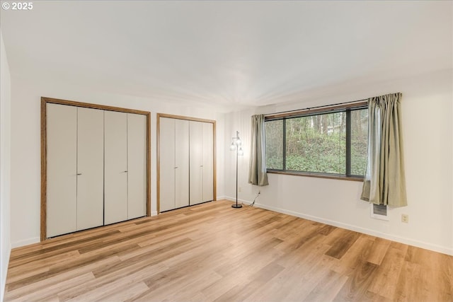 7148 SW Murray Blvd, Beaverton, OR 97008 - unfurnished bedroom with two closets, wood finished floors, and baseboards