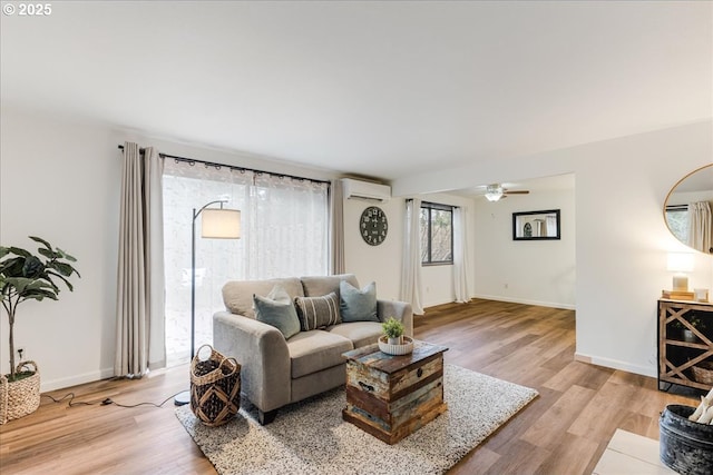 7148 SW Murray Blvd, Beaverton, OR 97008 - living area featuring a wall unit AC, light wood-type flooring, ceiling fan, and baseboards