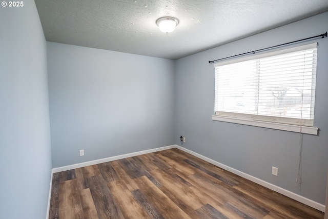 unfurnished room with dark wood-style floors, baseboards, and a textured ceiling