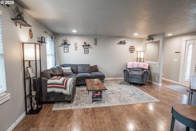 living area featuring recessed lighting, wood finished floors, and baseboards