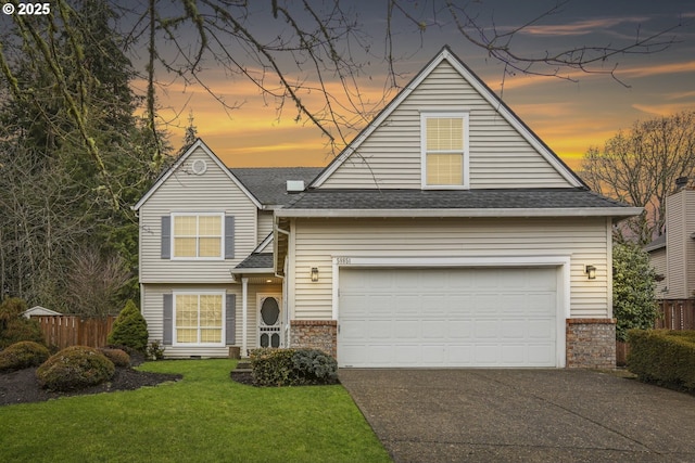 traditional-style home featuring aphalt driveway, brick siding, fence, a yard, and roof with shingles