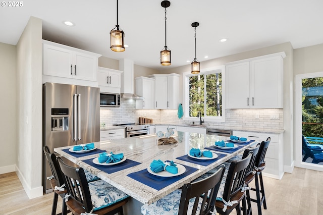 kitchen with plenty of natural light, decorative backsplash, appliances with stainless steel finishes, and a kitchen breakfast bar