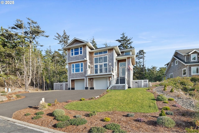 view of front of house featuring an attached garage, a front lawn, and aphalt driveway