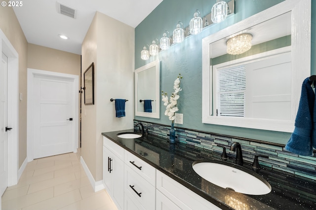 bathroom featuring tile patterned flooring, a sink, baseboards, and double vanity